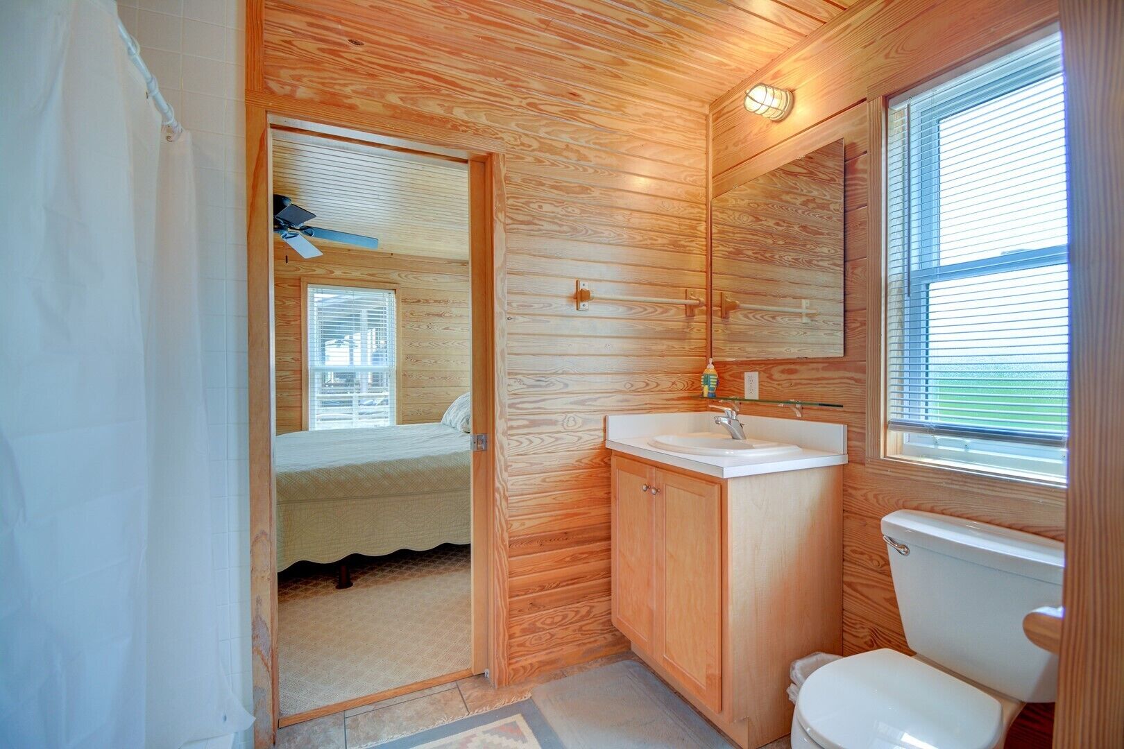 Un baño pequeño de madera con inodoro, lavabo y espejo.