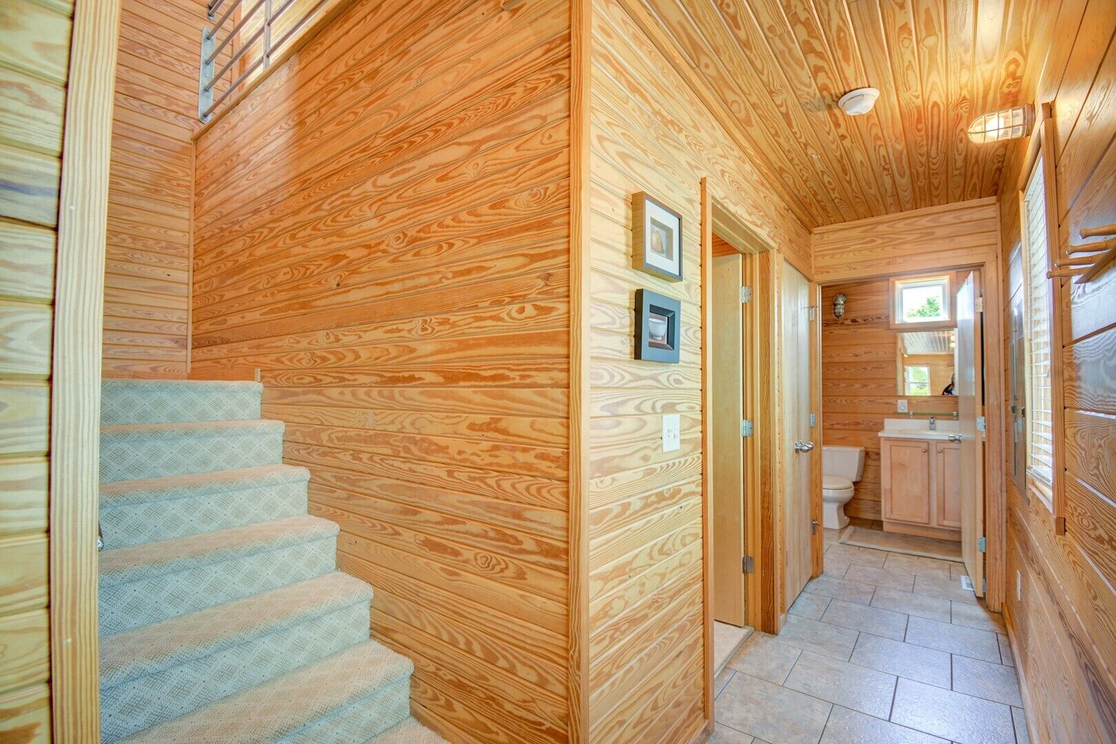 A wooden interior with a staircase leading to a bathroom.