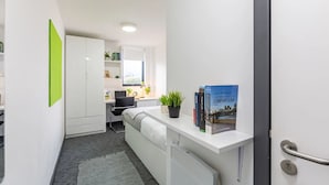 Um espaço de escritório moderno com uma mesa, cadeira e uma estante de livros.