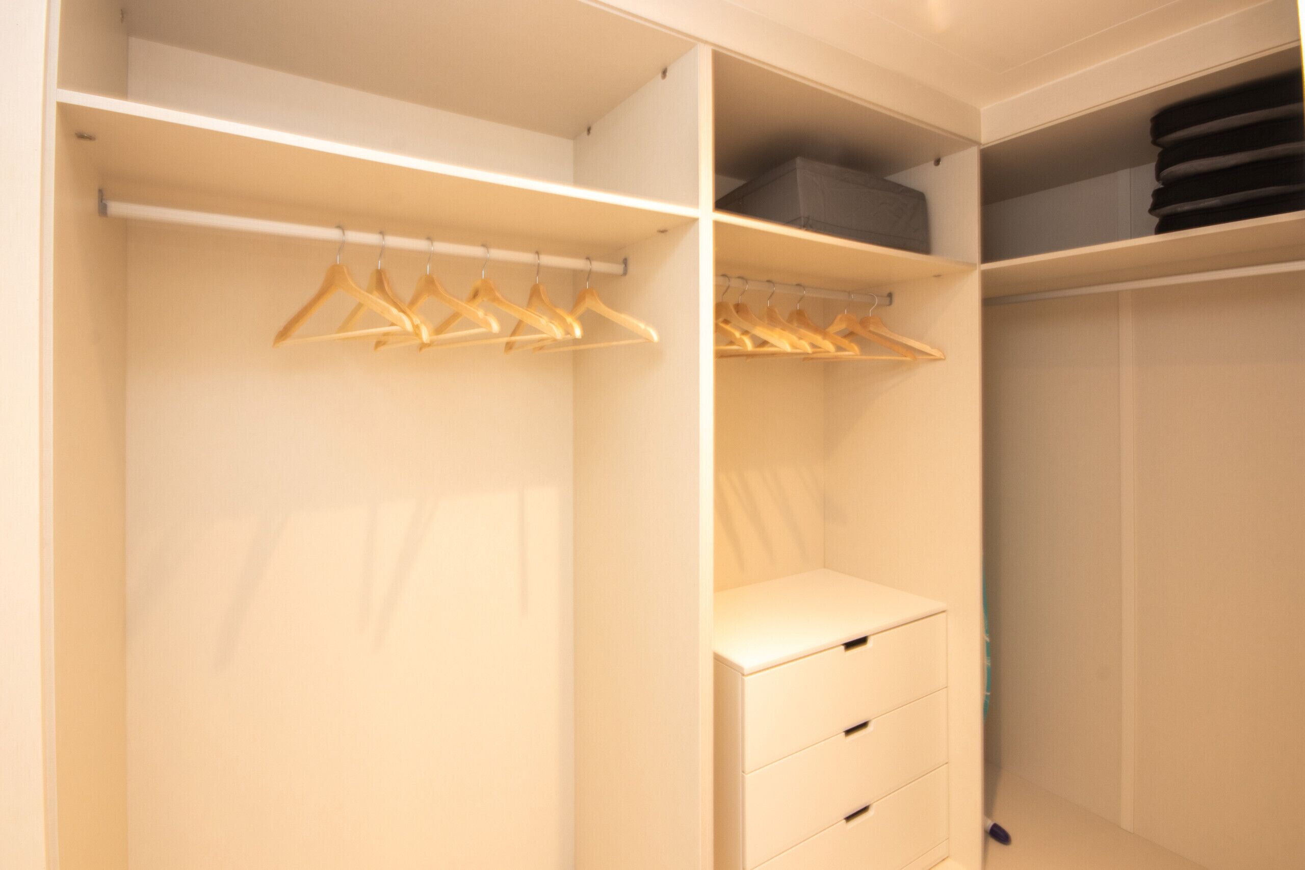 Ein begehbarer Kleiderschrank mit Kleiderhaken und Schubladen.