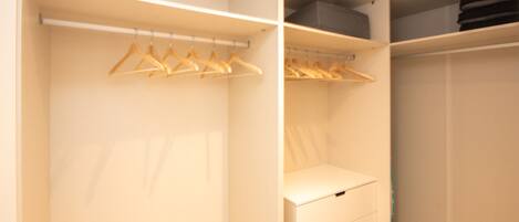 Ein begehbarer Kleiderschrank mit Kleiderhaken und Schubladen.