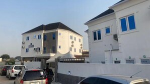 A multi-story building with a flat roof, several windows, and a gated entrance. - Ted G Hotel (Port Harcourt)