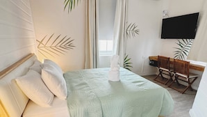 Een slaapkamer met een bed, bureau, stoel en televisie.