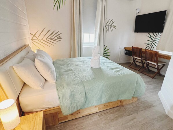 A bedroom with a bed, a desk, a chair, and a TV. - Eden On The Sea (Bridgetown)