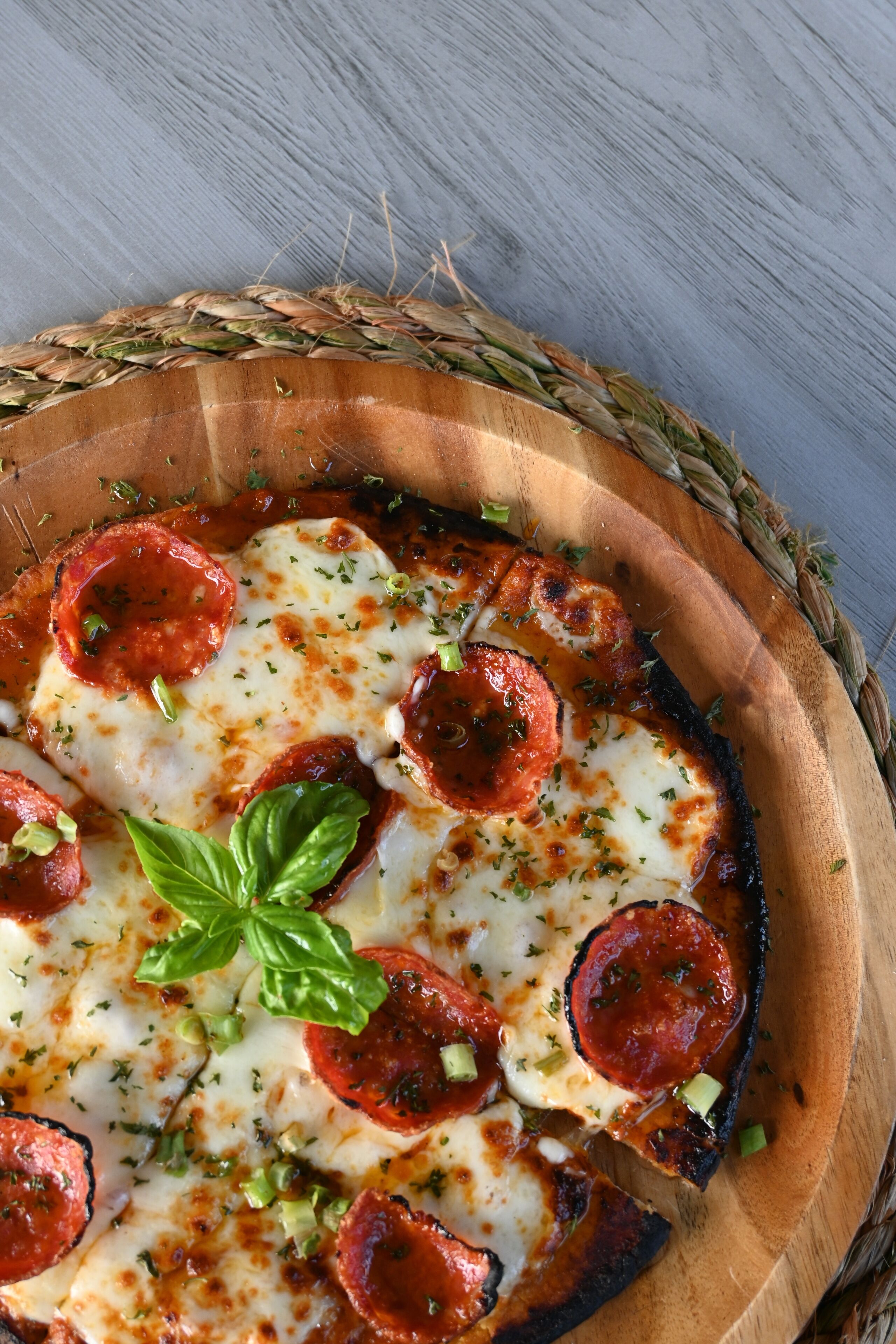 A pizza with pepperoni and cheese on a wooden board.