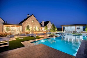 A modern house with a swimming pool, outdoor seating, and a well-lit patio area. - Ultra-Luxe Escape | Sleeps 16 | Minutes to RT (Carmine)