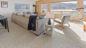 Una sala de estar acogedora con un sofá, una silla, una lámpara y un telescopio.