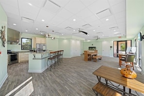 A spacious kitchen with modern appliances, a dining area with wooden furniture, and a ceiling with recessed lighting. - Luxury Condo with Airport Views Merritt Island (Merritt Island)