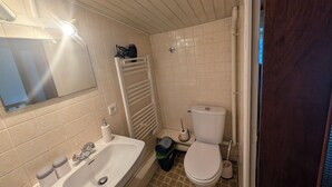 Une salle de bain avec un lavabo blanc, des toilettes et un porte-serviettes.