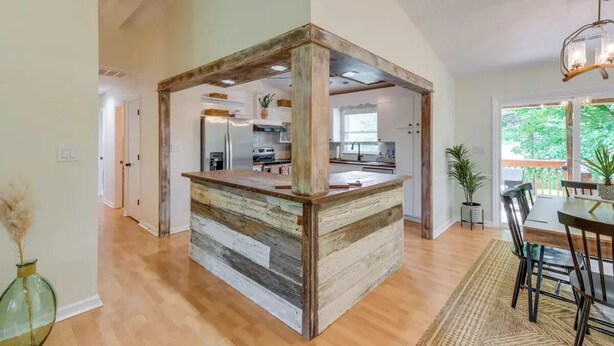 A spacious kitchen with a central island, wooden accents, and a view to the outdoors. - Pet-Friendly Lake Norman Retreat (Mooresville)