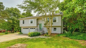A two-story house with a front porch, a green door, and a small front yard with trees and shrubs. - Pet-Friendly Lake Norman Retreat (Mooresville)
