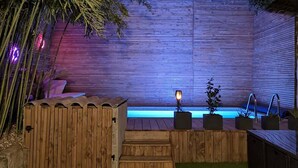 A wooden deck with a hot tub, surrounded by bamboo and a wooden fence. - Private room at the foot of the Cevennes (Lodève)