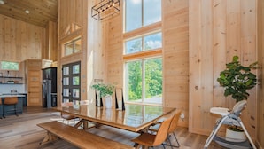 A spacious wooden interior with a large dining table, benches, and a high ceiling. - Casa Bella: Mtn Views, Movie Room, Games, Hot Tub, Wifi, Yard with Fire Pit! (Sevierville)