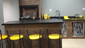 Cocina moderna con una isla central, taburetes de bar, iluminación colgante y estufa empotrada.