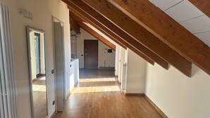 A hallway with wooden flooring and a sloped ceiling. - Orchidea Apartment (Seregno)
