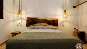 A bed with a quilted green bedspread, a wooden headboard, and two wall-mounted light fixtures. - Inigualable Suite, dos recamaras frente a Zicatela (Brisas de Zicatela)