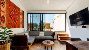 A modern living room with a sofa, coffee table, and TV. - Inigualable Suite, dos recamaras frente a Zicatela (Brisas de Zicatela)