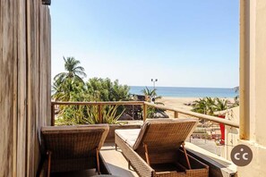 A balcony with wicker furniture overlooking a beach. - Magnifico Loft para 2 con Vista al Mar de Zicatela (Brisas de Zicatela)