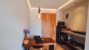 Una cocina compacta con una mesa de madera, una lámpara colgante y un horno empotrado.