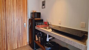 Una cocina moderna con microondas integrado, un lavamanos y una estufa.