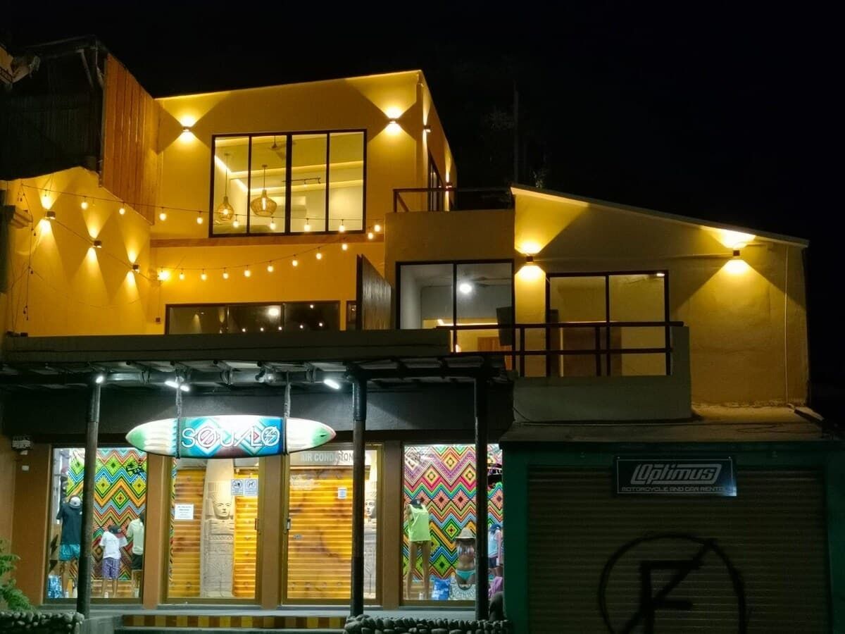 Un immeuble à plusieurs étages, doté de fenêtres illuminées et d’une vitrine.