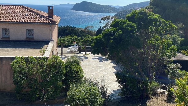 A coastal villa with a stone terrace, a view of the sea, and lush greenery. - Green oasis for 2 with huge private pool + optional guest house | French Riviera (Rayol canadel sur mer)