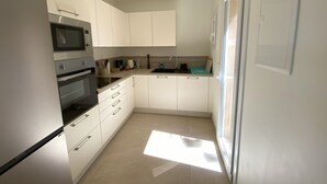 A modern kitchen with white cabinets, a built-in oven, and a microwave. - Green oasis for 2 with huge private pool + optional guest house | French Riviera (Rayol canadel sur mer)