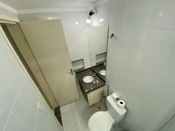 A bathroom with two sinks, a toilet, and a mirror.