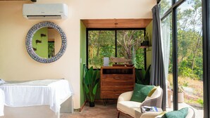 A bedroom with a bed, a chair, a dresser, a mirror, and a large window. - Kooteja Santa Catalina KAÏSA (Hicaco)