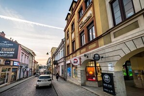 A street view with buildings, a car, and a pedestrian.