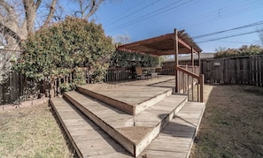 A wooden deck with steps leading to a covered patio area. - Launch Pad - 4 BR/2.5 BA - Close to Campus (Lubbock)