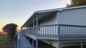 Un edificio de dos pisos con un porche cubierto y una pequeña terraza.