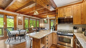 A spacious kitchen with wooden cabinets, a granite countertop, and stainless steel appliances.