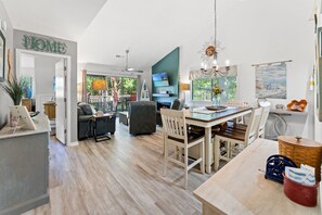 A spacious living area with a dining table, chairs, a fireplace, and a TV.
