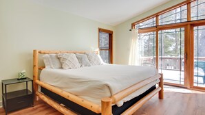 Un lit en bois dans une pièce dotée d’une grande fenêtre donnant sur l’extérieur.