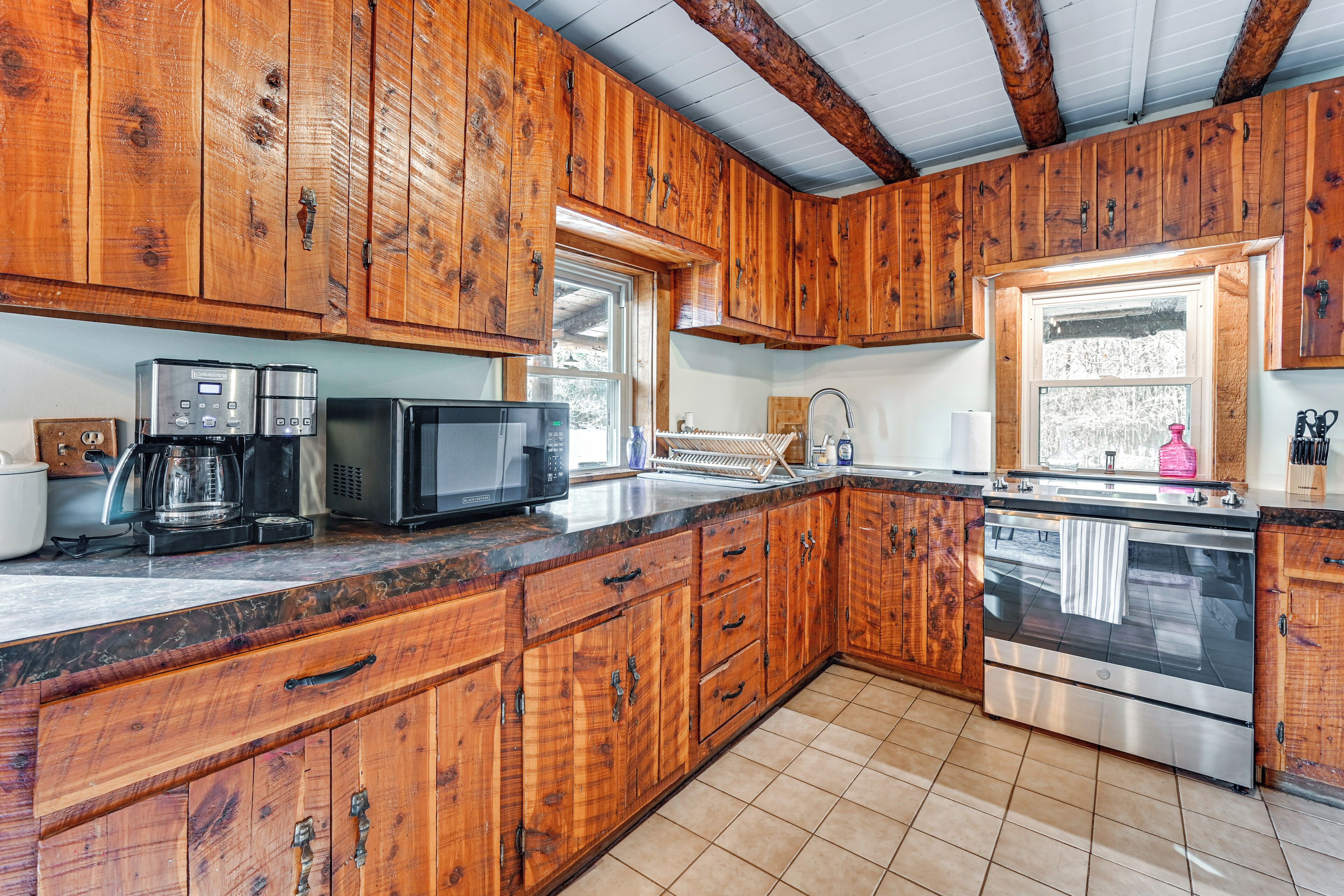 A kitchen with wooden cabinets, a stainless steel oven, a microwave, and a coffee maker.