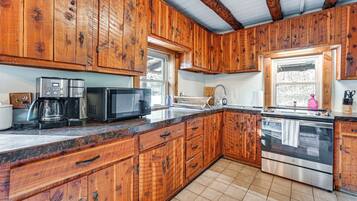 A kitchen with wooden cabinets, a stainless steel oven, a microwave, and a coffee maker.
