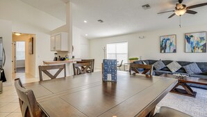 A spacious living area with a dining table, sofas, and a ceiling fan. - 9 Mi to Disney: Home w/ Pool Table & Water Views! (Kissimmee)