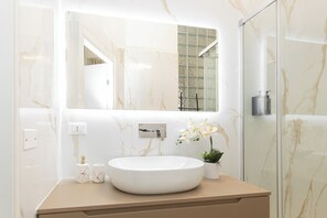 Habitación triple de lujo | Baño | Ducha, secador de pelo, toallas y jabón