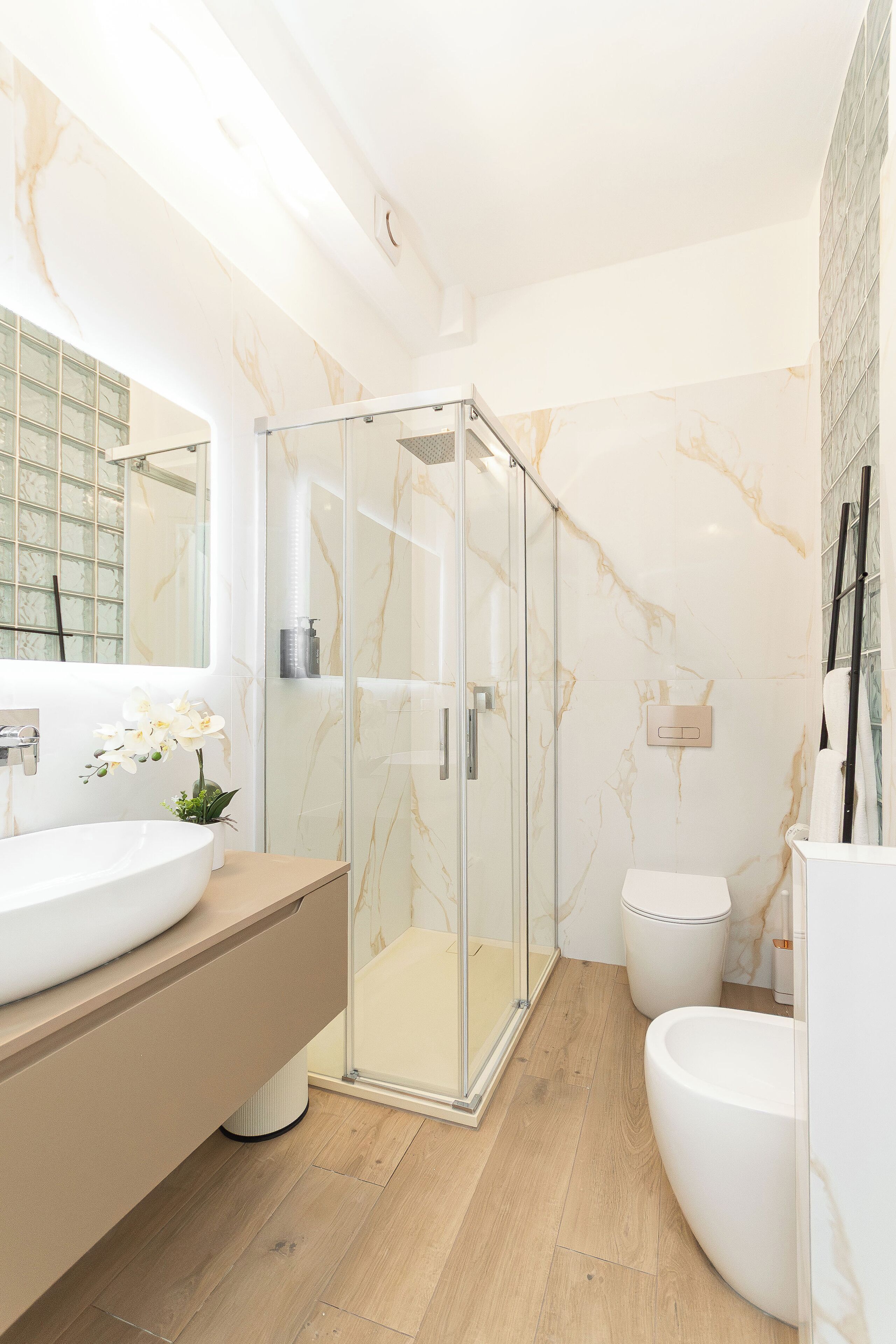 Luxe driepersoonskamer | Badkamer | Een douche, een haardroger, handdoeken, zeep