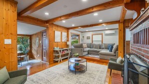 A spacious living room with wooden beams, a fireplace, and a cozy seating area.