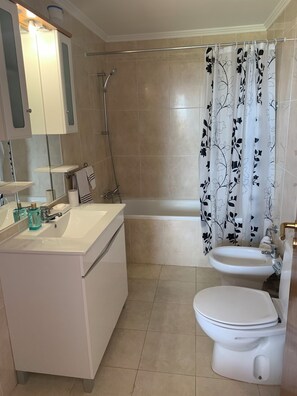 A bathroom with a white sink, a toilet, a bathtub, and a shower.
