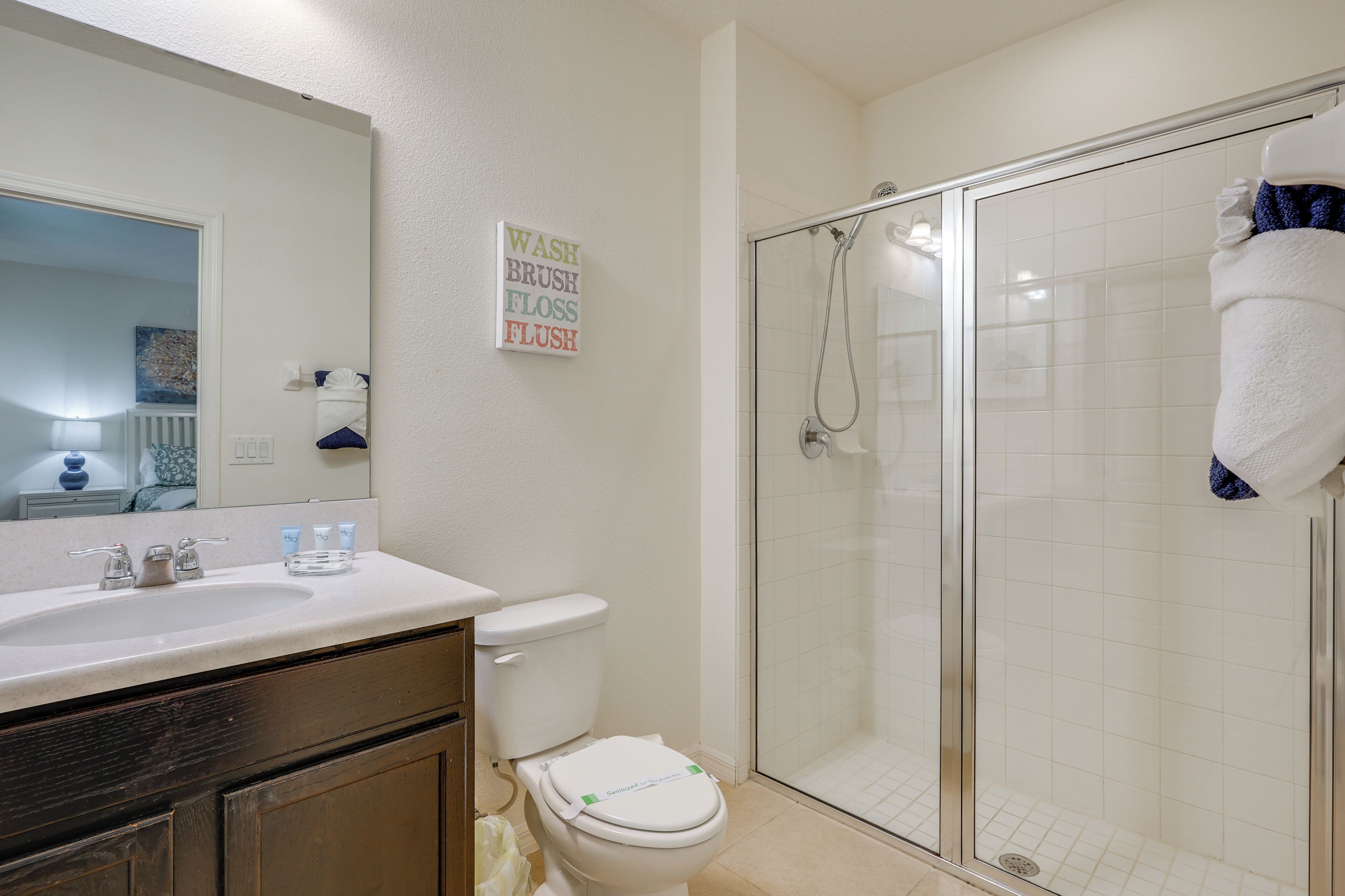 Une salle de bain équipée d’un lavabo, de toilettes et d’une douche à parois en verre.