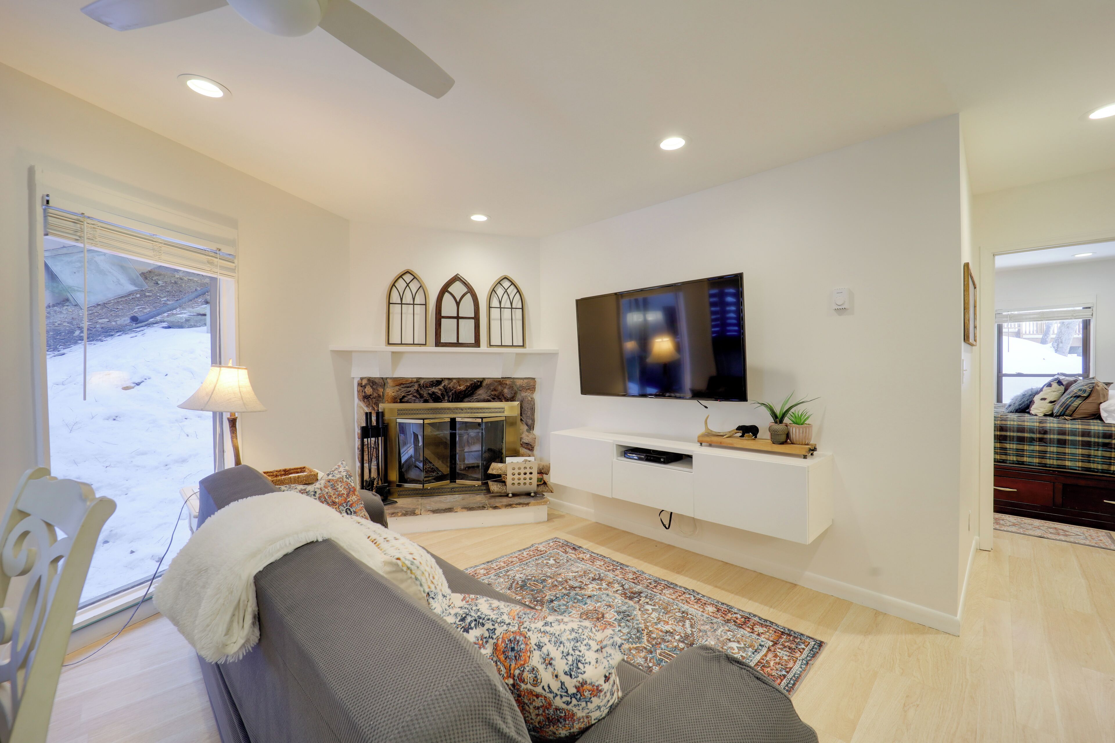 Una sala de estar moderna con chimenea, un televisor de pantalla plana en la pared y una zona de estar acogedora con un sofá y una butaca.