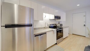 A modern kitchen with stainless steel appliances, white cabinetry, and a microwave. - Ski, Hike & More! Couple's Getaway in Beech Mtn (Banner Elk)