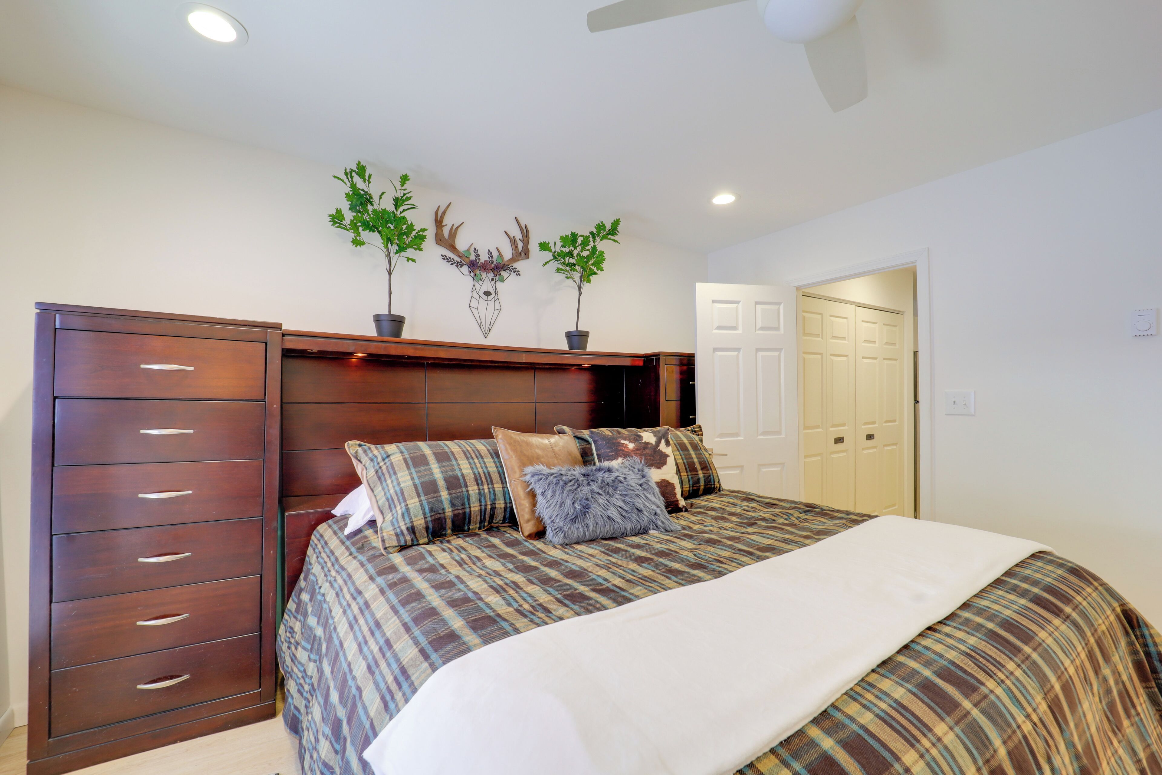 A bedroom with a bed, a dresser, and a door.