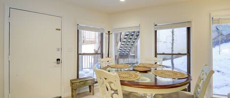 A dining area with a round table, chairs, and a bench.