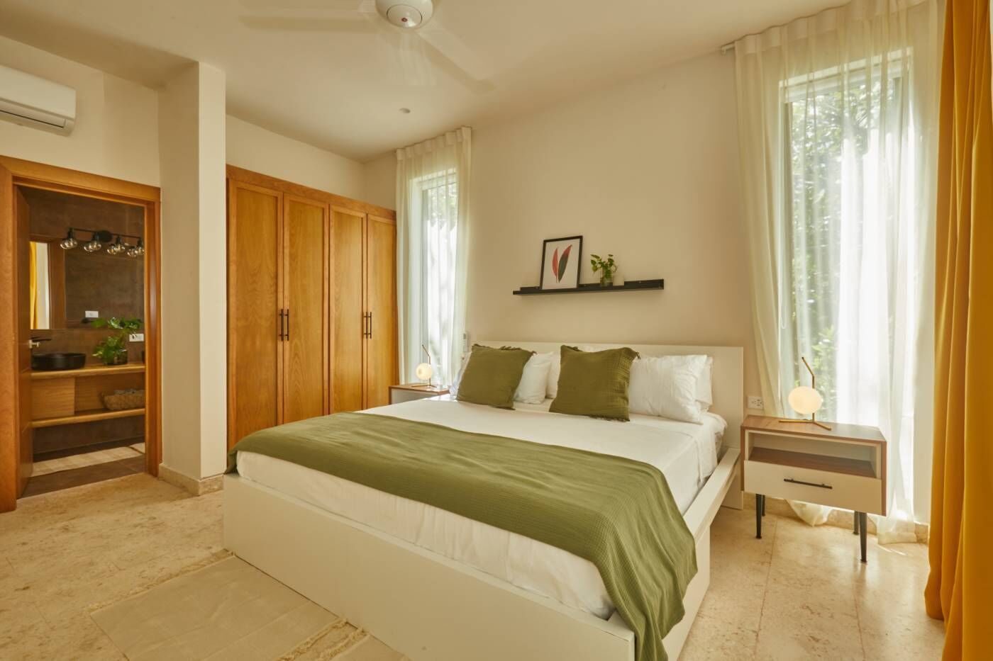 A bedroom with a bed, a nightstand, a wardrobe, and a window with curtains.