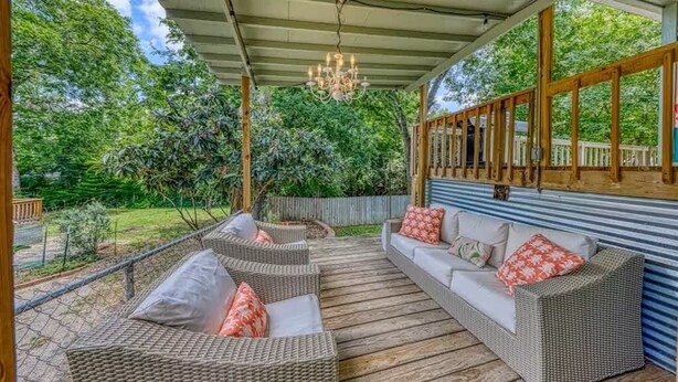 A covered outdoor seating area with wicker furniture and a chandelier. - DT 332 Havana Haus (New Braunfels)