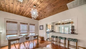 A dining area with a wooden table, chairs, and a cowhide rug. - DT 332 Havana Haus (New Braunfels)